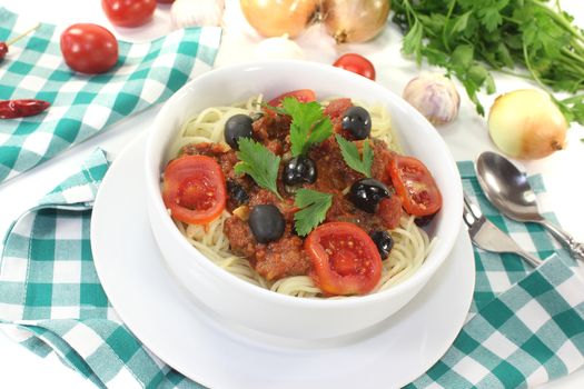 Spaghetti alla puttanesca with tomatoes on light background