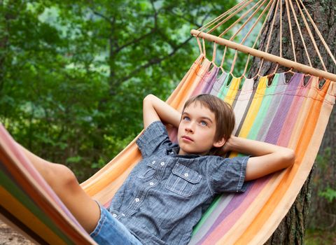 Boy lying in hammock outdoors