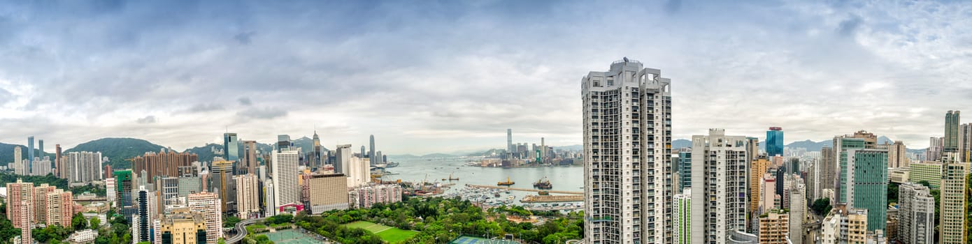 HONG KONG - MAY 12, 2014: Stunning panoramic view of Hong Kong Island and Kowloon on a cloudy day. Last year HK hosted more than 54 million visitors, most of them from the mainland.