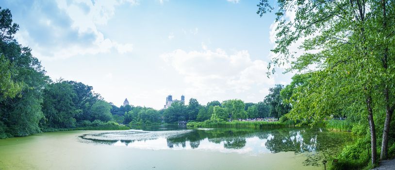 Park lake in the middle of the city with people relaxing.