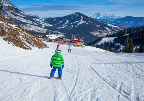 Ski, skier, winter - back view of lovely small boy has a fun on ski