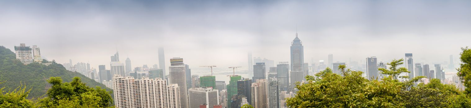 HONG KONG - MAY 12, 2014: Stunning panoramic view of Hong Kong Island and Kowloon on a cloudy day. Last year HK hosted more than 54 million visitors, most of them from the mainland.