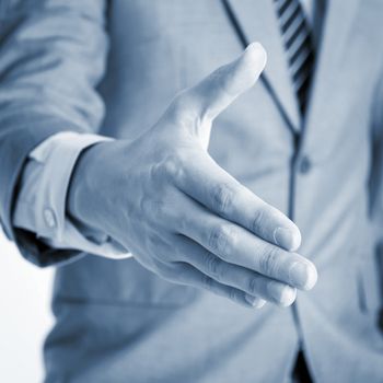 Close up businessman offer hand shake, in blue toned effect.