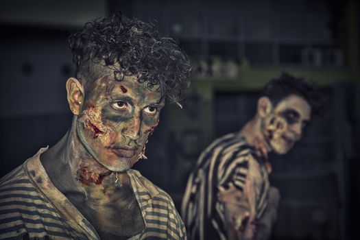 Two male zombies standing outdoor at night for Halloween. Sick green tint. Halloween theme