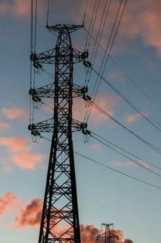 The silhouette of the power tower against the blue sunset sky