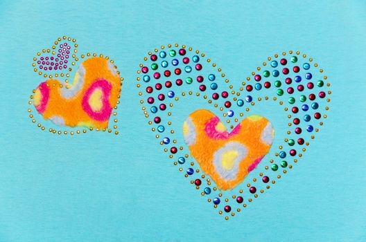 Two heart fluff and sequin, Decoration on a blue fabric background
