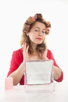 middle-aged woman in red with hair rollers - isolated on white