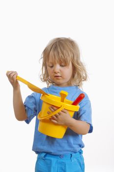 boy with long blond hair carrying colorful plastic beach toys - isolated on white