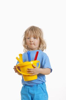 boy with long blond hair carrying colorful plastic beach toys - isolated on white