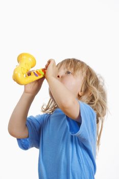 boy with long blond hair playing with toy saxophone