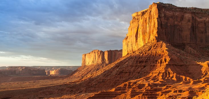 Orange colours during sunrise in this iconic view of Monument Valley, USA