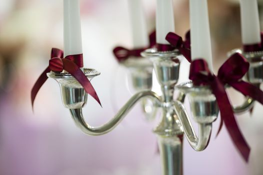 Candle decoration detail with red bow on ceremony table