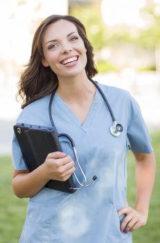 Portrait of An Attractive Young Adult Woman Doctor or Nurse Holding Touch Pad Outside.