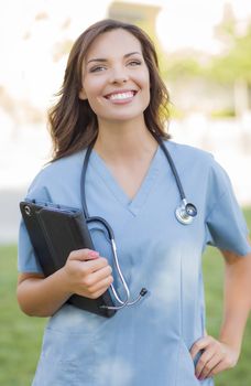 Portrait of An Attractive Young Adult Woman Doctor or Nurse Holding Touch Pad Outside.