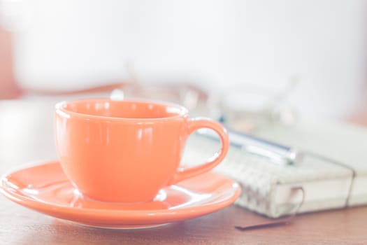 Mini orange coffee cup with notebook, stock photo