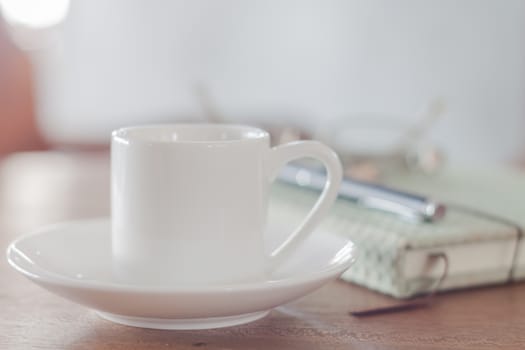 Mini white coffee cup with notebook, stock photo