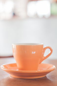 Orange mug on wooden table, stock photo