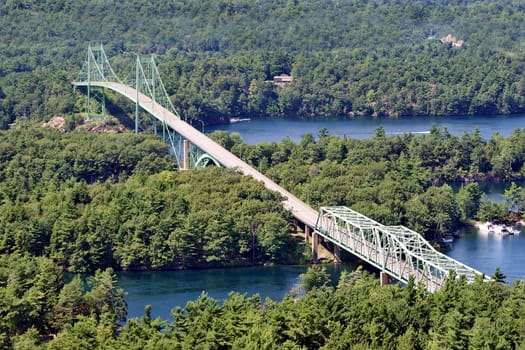 Photo shows Canadian countryside view with trees and bridge.