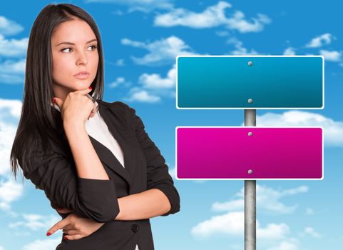 Thoughtful businesswoman and road sign. Blue sky with clouds in the background