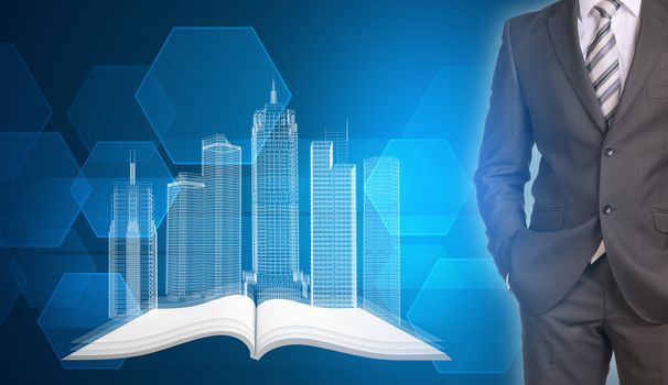 Businessman in suit standing and holds hands in pockets. Glowing wire-frame buildings on open empty book as backdrop