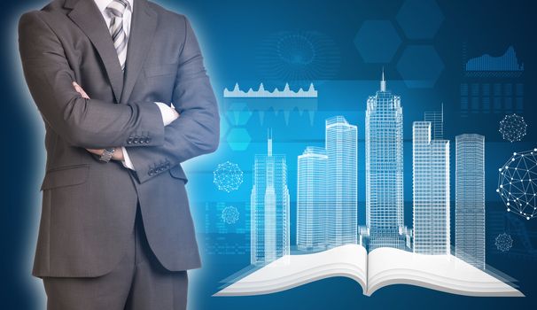 Businessman in suit stands with his arms crossed. Glowing wire-frame buildings on open empty book as backdrop