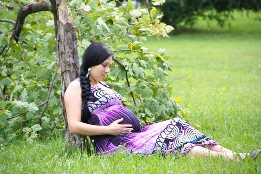 The pregnant girl on walk in city park