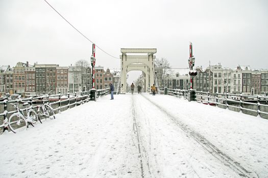 Snowy Amsterdam with the Thiny bridge in the Netherlands