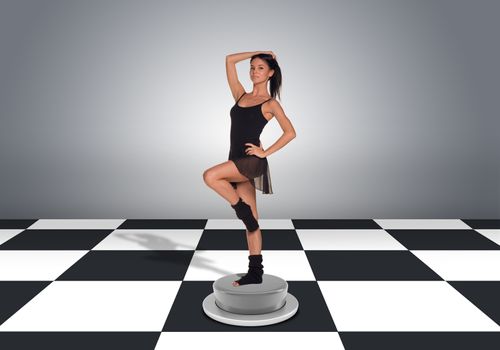 Beautiful dancer posing and looking at camera. Floor with checkerboard texture and gray wall