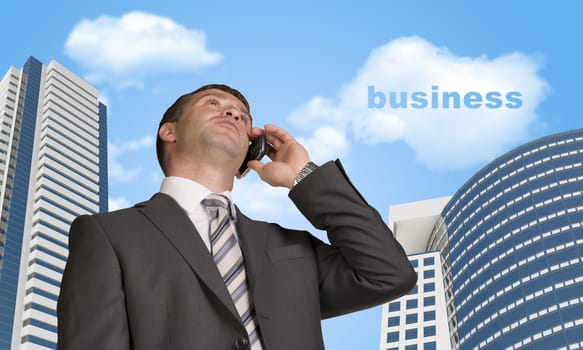 Businessman talking on the phone. Skyscrapers and cloud with word business in background
