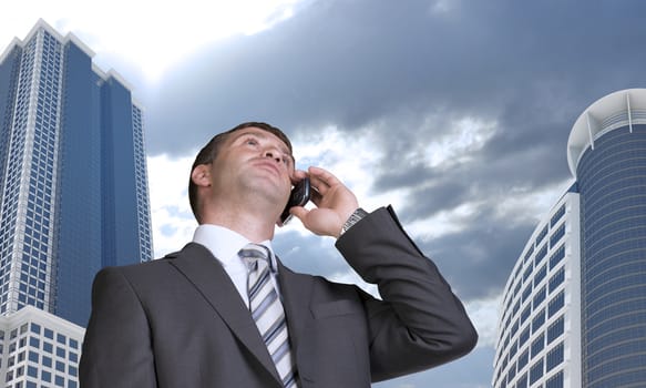 Businessman talking on the phone. Skyscrapers and clouds in background