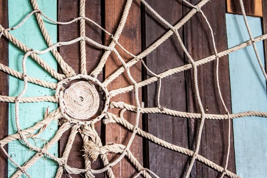 Spider web made of rope on the wood wall