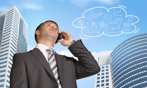 Businessman talking on the phone. Skyscrapers and cloud with business sketches in background