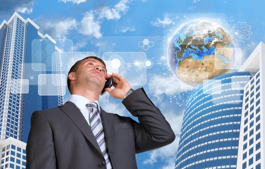 Businessman talking on the phone. Skyscrapers and Earth with transparent rectangles. Element of this image furnished by NASA