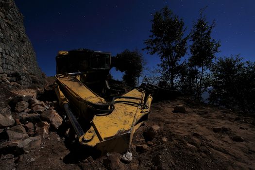 Inverted excavator on the road. Moonlit Night in the Himalayas. Nepal