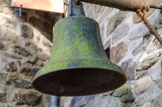 Old bell suspended on a metal bracket
