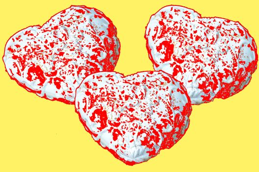 Three red white hearts of stone against a yellow background
