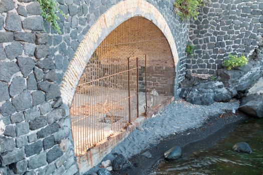 tunnel with mettallic gate on the beach