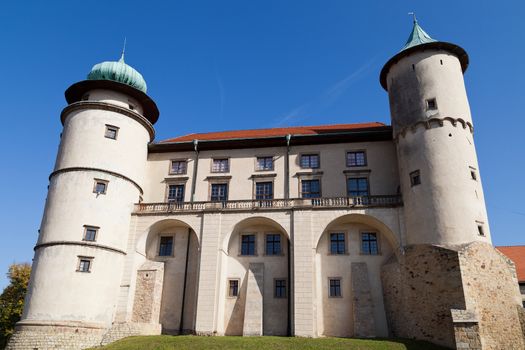view on castle Nowy Wisnicz in Poland on a background of blue sky