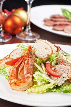 Tasty shrimp salad with vegetables on christmas table