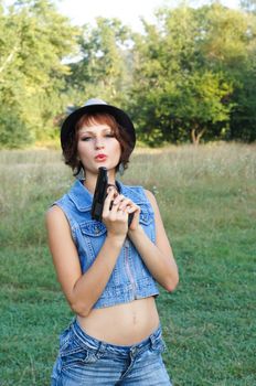 The girl in a hat with a pistol