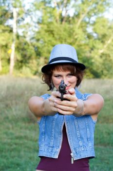 The girl in a hat with a pistol