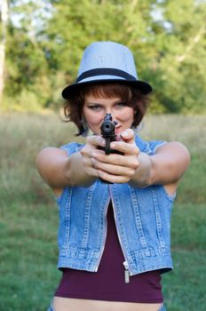 The girl in a hat with a pistol