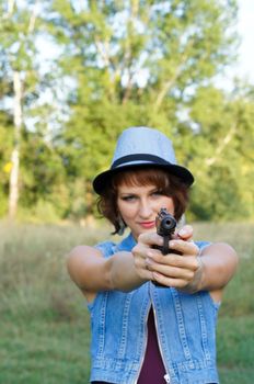 The girl in a hat with a pistol