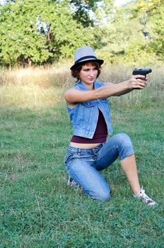 The girl in a hat with a pistol