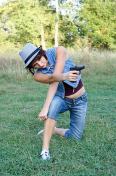 The girl in a hat with a pistol