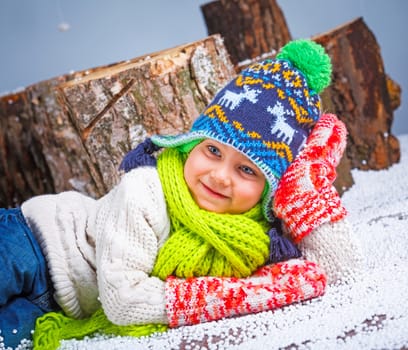 Winter Fashion. Portrait of adorable happy boy in winter hat, gloves and sweater in studio.
