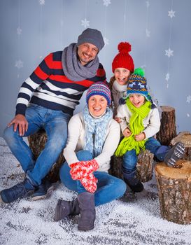 Winter Fashion. Happy family in winter hat, gloves and sweater in studio.