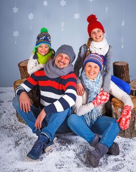 Winter Fashion. Happy family in winter hat, gloves and sweater in studio.