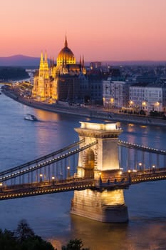 Budapest cityscape sunset with Chain Bridge in front over Danube river and with Parliament Building in the background.