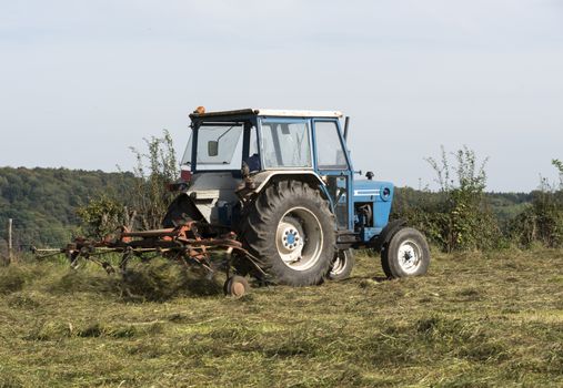 farmer at work with tractor mowing grass